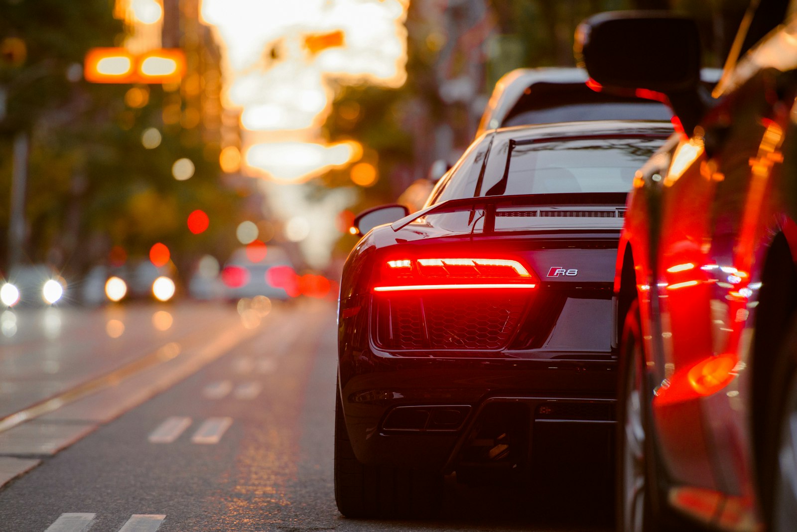 Sports car at the curb at night, taillights glowing